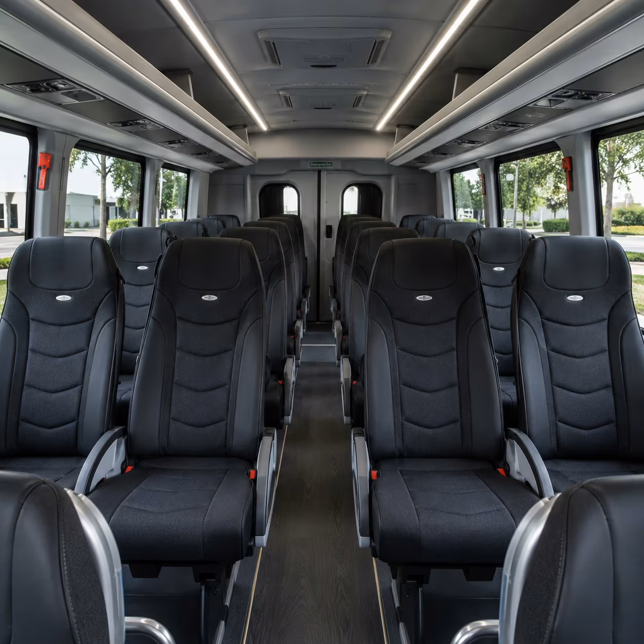 Interior aisle of a minibus with rows of cushioned passenger seats