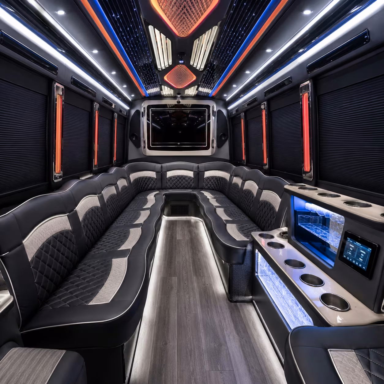 Interior of a party bus with wraparound leather seating and LED accent lighting